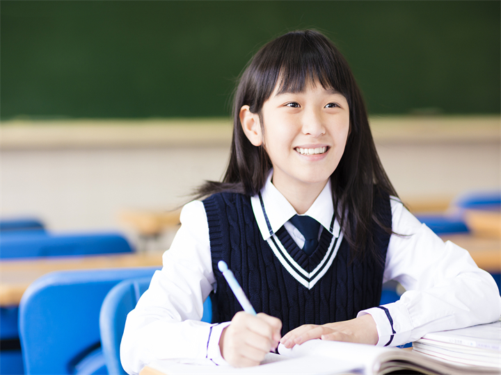 快樂(lè)漂亮的學(xué)生女孩與書(shū)在教室里.jpg
